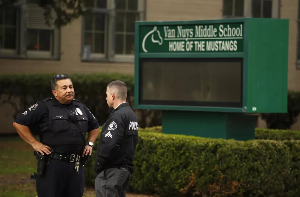 Police officers confer in front of Van Nuys Middle School, where10 students were treated for possible overdoses of an unknown substance. (Genaro Molina/Los Angeles Times)
